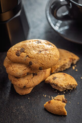 Biscotti frollini con gocce di cioccolato. Chocolate cookies on black table.