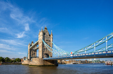 Obraz premium Tower Bridge over Thames river famous tourist landmark with cruise in river transportation for travel in center city of London, UK, United Kingdom, British or England in summer with clear blue sky