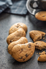 Biscotti frollini con gocce di cioccolato. Chocolate cookies on black table.