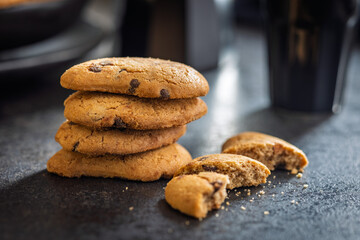 Biscotti frollini con gocce di cioccolato. Chocolate cookies on black table.
