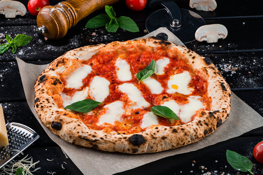 Italian pizza Margarita with mozzarella, tomato sauce, spinach on a thick dough.