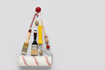 Christmas tree made of painter's tools and decorations on light background