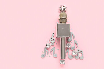 Christmas tree made of microphone, note signs and decorations on pink background