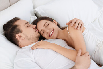 Happy couple spending time together on bed at home