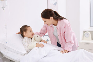 Obraz premium Mother and her little daughter on bed in hospital