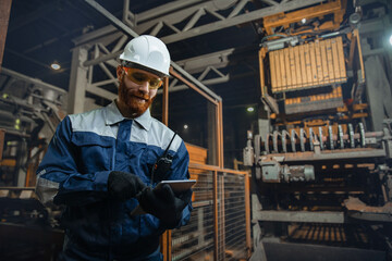 Man engineer use tablet computer, working in manufacturing factory of bricks