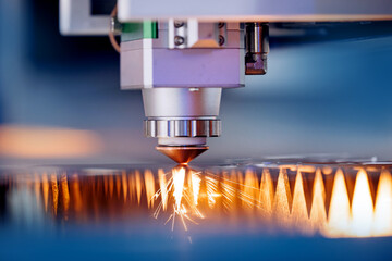 Laser CNC cut of metal with light spark. Technology modern industrial blue color