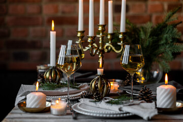 Rustic Scandinavian style zero waste eco-friendly dinner table decor for Christmas or new year family celebration. Wooden table, natural elements like pine cones, fir tree branches, candles