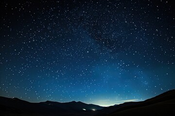 A stunning view of a clear night sky filled with stars over a mountainous landscape, showcasing the beauty of the cosmos in a tranquil setting near the horizon at twilight