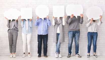 Naklejka premium Social opinion concept. Group of people hiding faces behind blank speech bubbles, free space