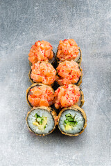 Set of hot sushi rolls with salmon, tobiko caviar, cucumber, avocado, tempura.