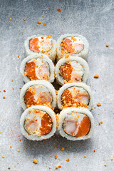 Set of sushi rolls with shrimp, tamago omelet, cream cheese, salmon, rice and nori topped nuts.