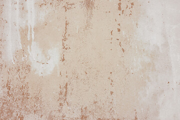 Textured brown plaster wall surface with peeling paint. Aged, weathered concrete background