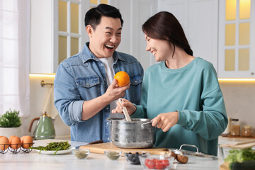 Happy lovely couple cooking together in kitchen