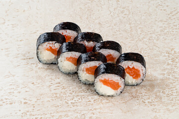 Traditional Japanese kitchen set of sushi rolls with salmon, cream cheese, rice and nori.