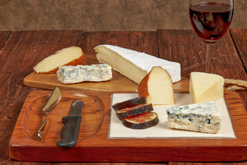 A board with different cheeses with great flavour and texture, accompanied by a glass of reserve red wine.