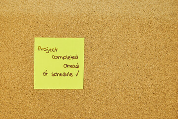 Post It notes with resolutions and goals achieved, placed on the cork board at the foot of a desk
