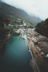 Obraz premium Rainy autumn landscape with colorful foliage and a river on a foggy day