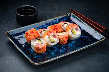 Set of sushi rolls with tuna, cream cheese, mango and flying fish caviar and soy sauce.