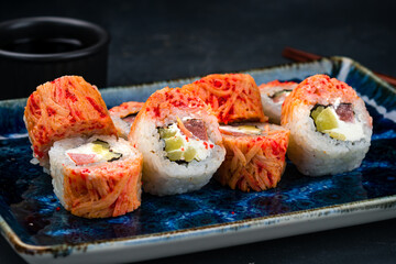 Sushi rolls with tuna, cream cheese, mango and flying fish caviar, closeup.