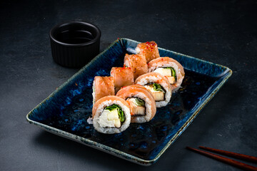 Set of sushi rolls with seared tuna, cream cheese, zucchini, lettuce and soy sauce.