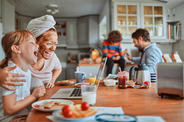 Family laughing during breakfast in kitchen