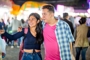 Latin couple stroll through the streets of their city during an evening stroll and do some shopping.