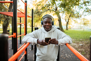 Older man resting on park bench after outdoor workout at fitness park
