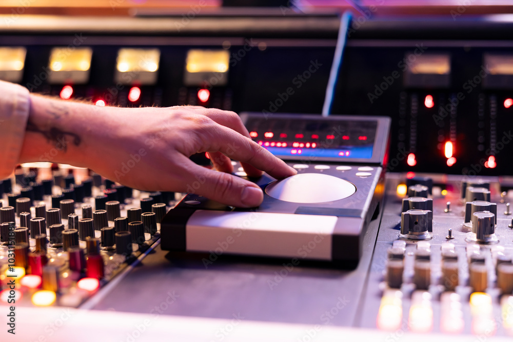 Aufkleber Skilled sound engineer operating mixing console and motorized faders in studio, using technical equipment to edit and process new tracks in control room. Young composer producing songs. Close up.