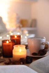 Burning candles, coffee and decor on tray indoors. Autumn atmosphere