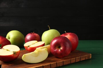 Fresh ripe apples on green wooden table