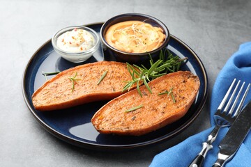 Halves of tasty baked sweet potato served on grey table