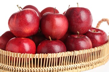 Fresh ripe red apples in wicker tray isolated on white
