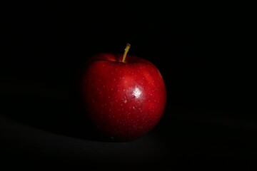 Fresh ripe red apple on black background, closeup
