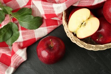 Fresh ripe red apples and green leaves on grey textured table