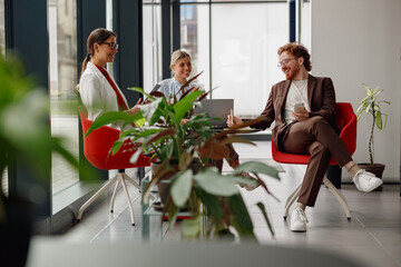 A group of professionals sharing innovative ideas in a stylish, green office that promotes teamwork...