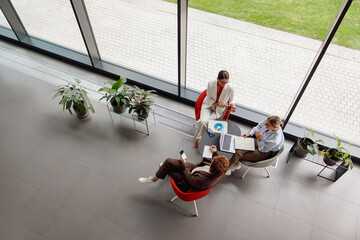 Professionals engage in a lively discussion about innovative ideas in a stylish, welllit office...