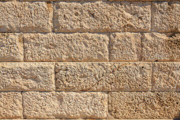 A brick wall with a rough texture and a few cracks