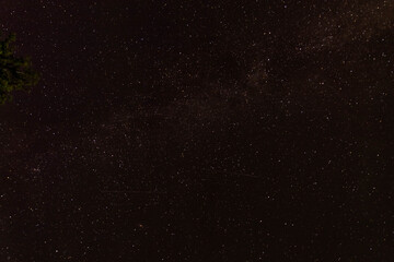 Milky Way stars with meteor shower trails and countryside silhouettes