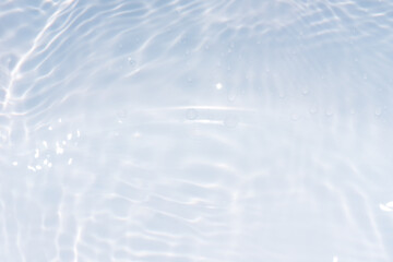 Obraz premium Blue water with ripples on the surface. Defocus blurred transparent blue colored clear calm water surface texture with splashes and bubbles. Water waves with shining pattern texture background.