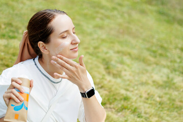 Young Caucasian Woman Is Applying Sunscreen Cream On Her Hand To Protect Her Skin While Hiking In The Mountains. Concept Of Outdoors Skincare For Hiking, Climbing, And Backpacking.