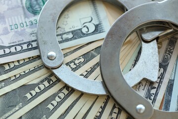 Handcuffs and a lot of dollars scattered on the table