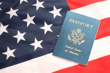 Fototapeta premium Latest version of United States of America citizen Passport on USA national flag