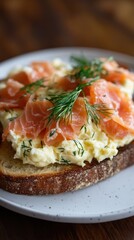 Delicious fluffy scrambled eggs with smoked salmon and fresh dill on rustic bread for food photography