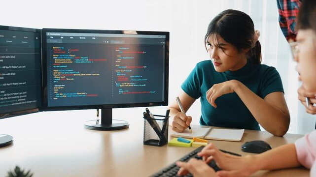 Slow motion back end software developer engineer for computer programming working together on debugging writing computing code, solving complex algorithms display on monitor in office. Burgeoning