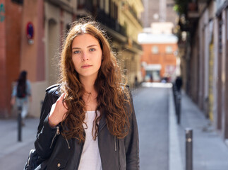 Obraz premium Portrait of a positive confident girl, standing in good weather on the street