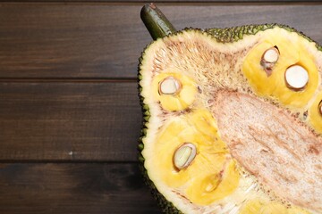 Half of delicious exotic jackfruit on wooden table, top view. Space for text