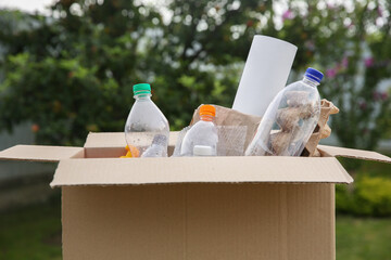 Obraz premium Recycling. Different garbage in cardboard box outdoors