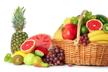 Many different fresh fruits in wicker basket isolated on white