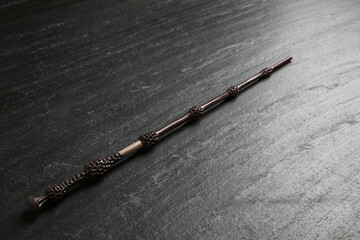 Obraz premium One old magic wand on black table, closeup